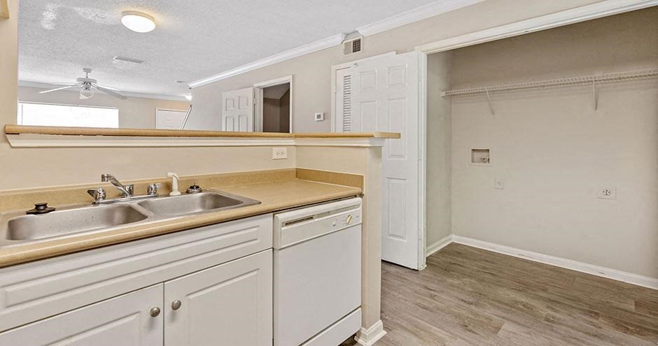 a kitchen with white cabinets and a sink and a doorway