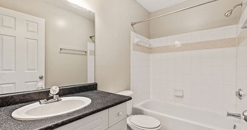 a white bathroom with a sink and a bath tub
