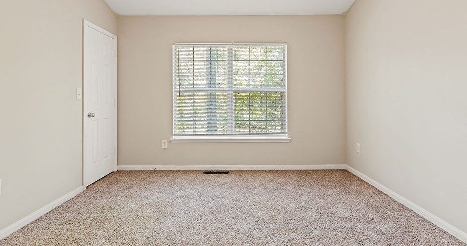 an empty room with a window and a door