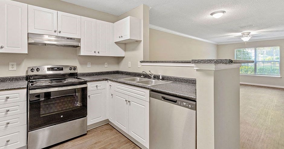 a kitchen with white cabinets and a stove and a sink