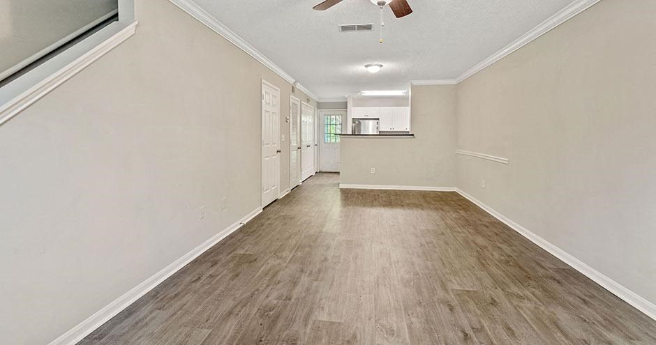 a empty living room with white walls and wood floors