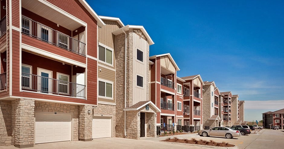 a row of town houses with cars parked in front of them