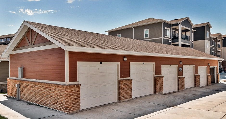 a row of garages with white doors in front of an apartment building