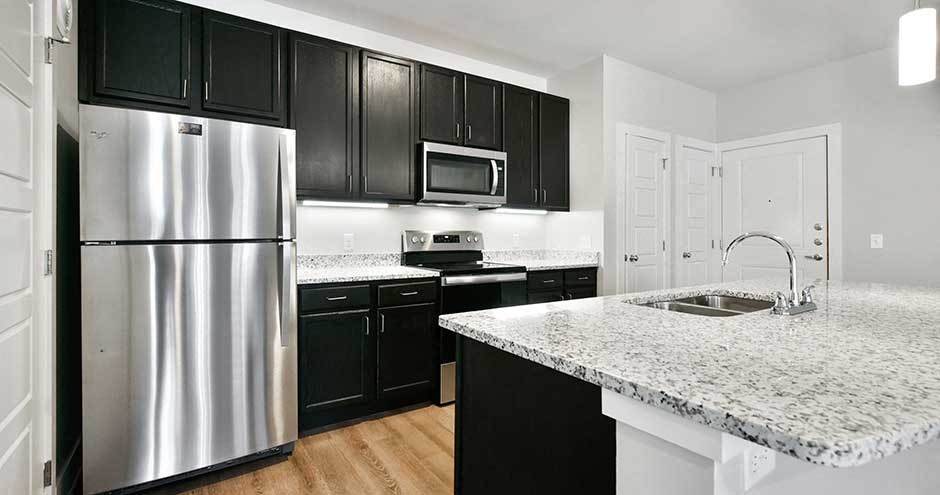 a kitchen with a marble counter top and a refrigerator