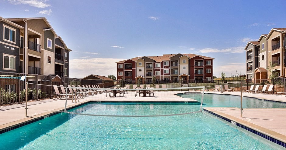 a swimming pool with an apartment building in the background