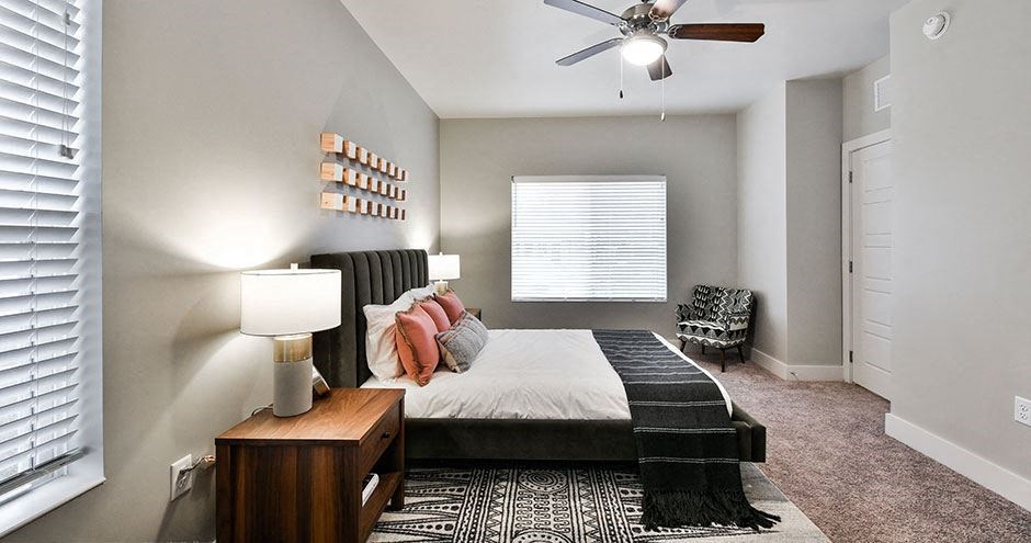 a bedroom with a bed and a ceiling fan