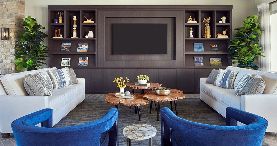 a living room with blue chairs and a television