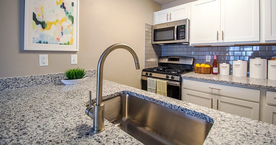 a kitchen with granite countertops and a stainless steel sink