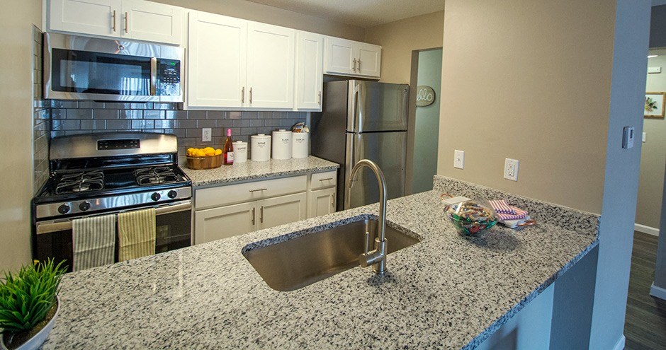 a kitchen with granite countertops and stainless steel appliances