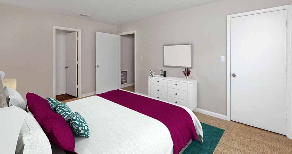 a bedroom with a white bed and a white dresser