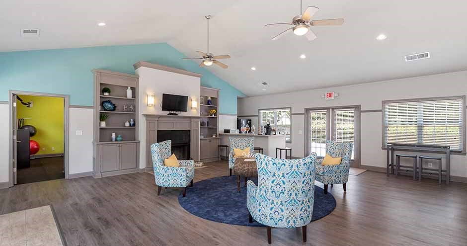 a living room with blue chairs and a fireplace