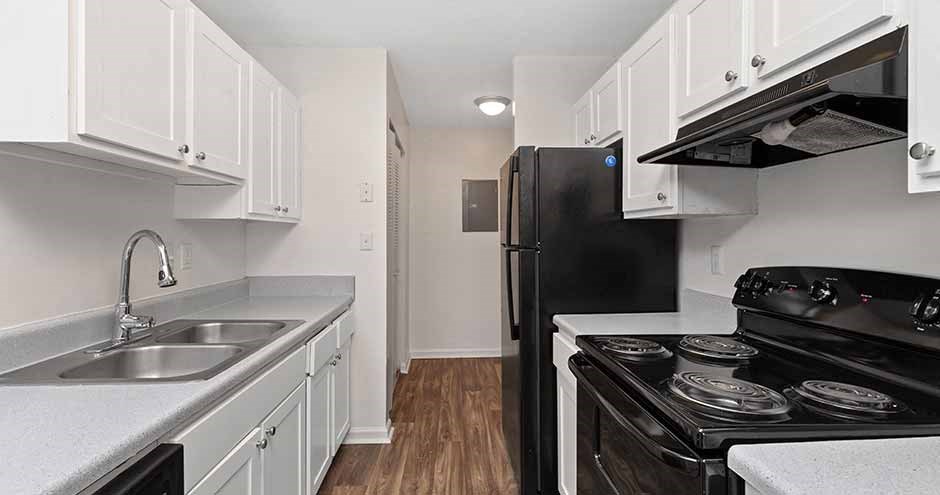 a kitchen with black appliances and white cabinets