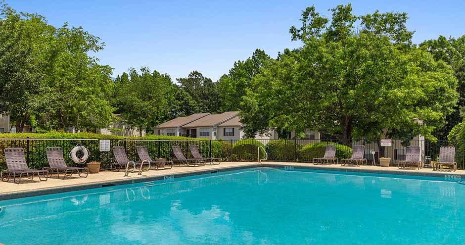 a large swimming pool with chairs around it