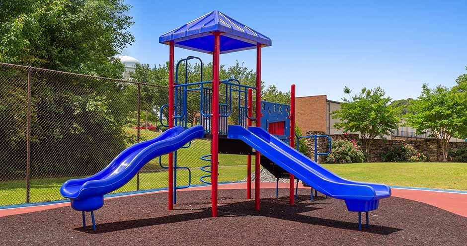 a playground with two slides and a swing set