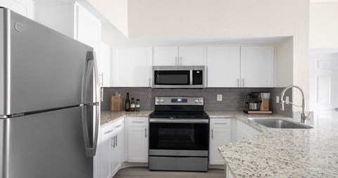 a kitchen with stainless steel appliances and white cabinets