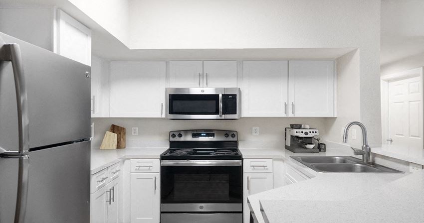a kitchen with stainless steel appliances and white cabinets