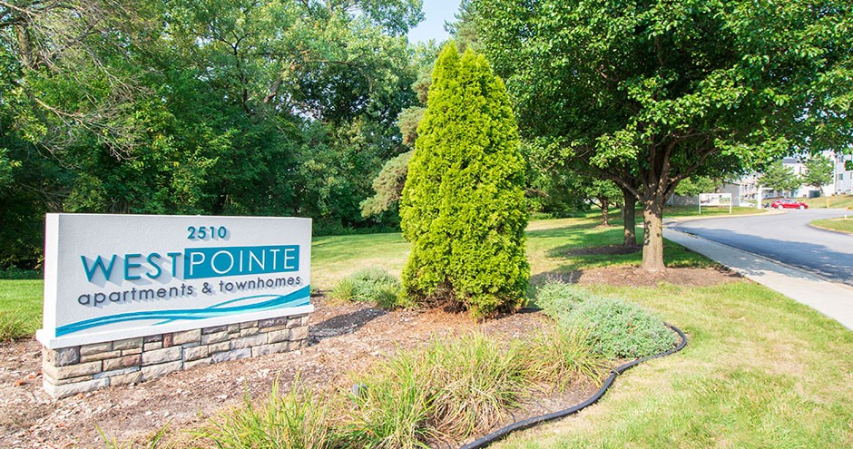 a sign for westpoint apartments and townhomes on the side of a road