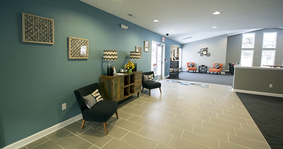 a living room with chairs and a table and a blue wall