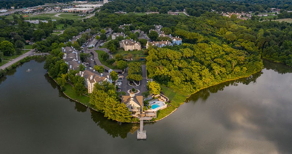 an aerial view of a mansion in the middle of the water