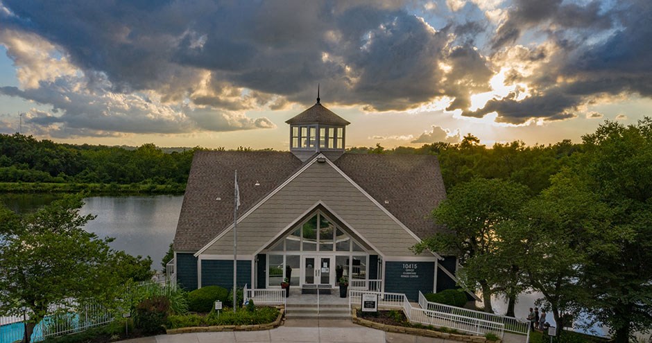 the boat house at sunset with the sun setting over the lake