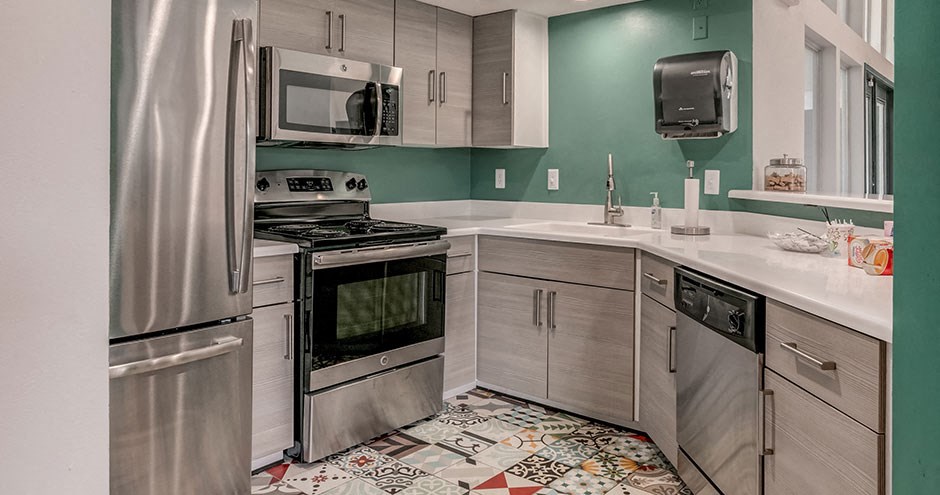 a kitchen with stainless steel appliances and white counter tops