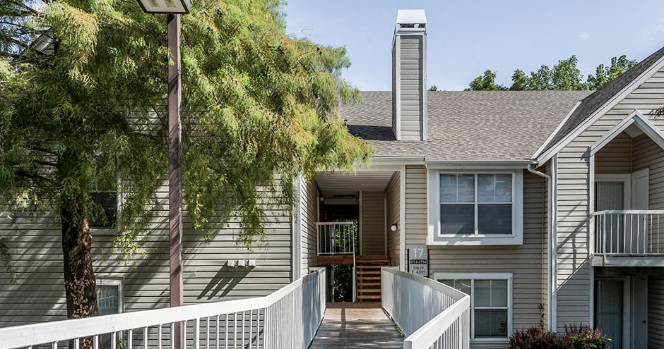 a white house with a porch and a tree