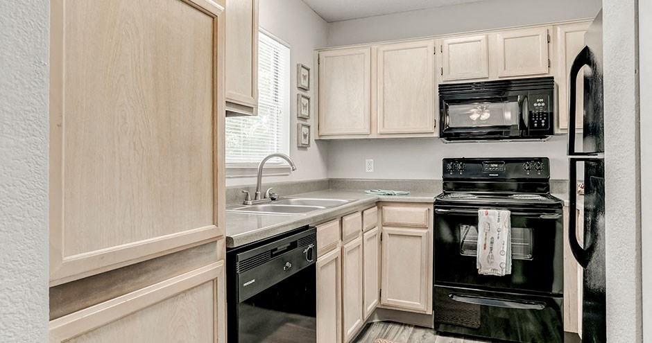 a kitchen with black appliances and white cabinets