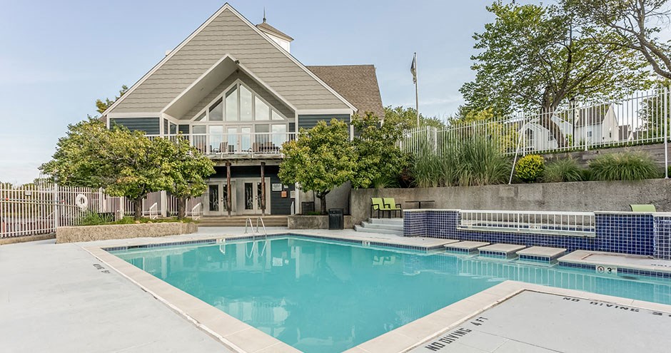 a swimming pool in front of a house with a pool