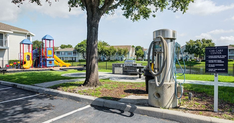 a gas pump in a park near a playground
