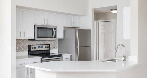 a white kitchen with a stove and a refrigerator