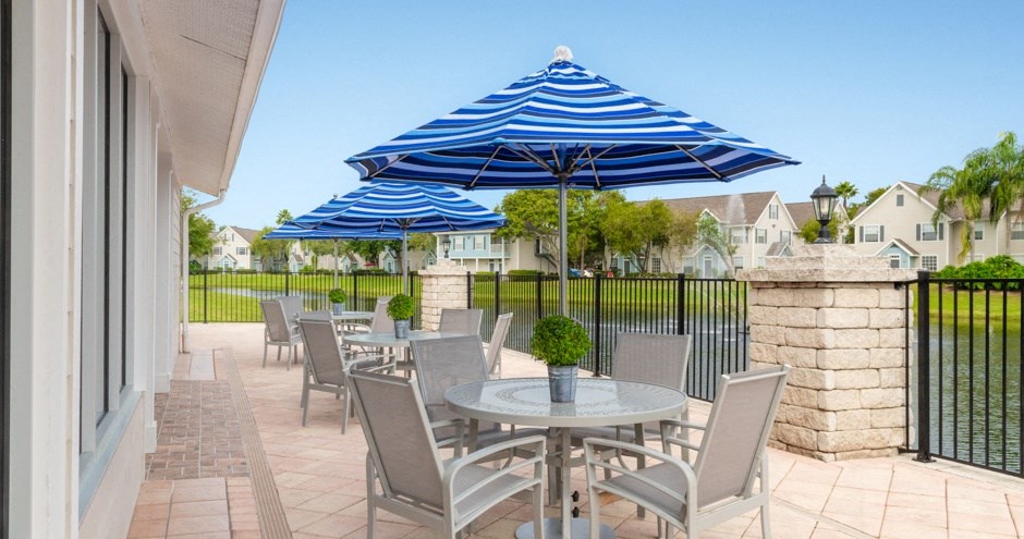 a patio with tables and chairs and umbrellas