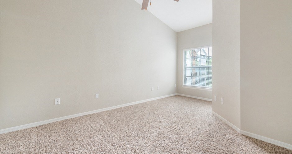 an empty room with carpet and a window