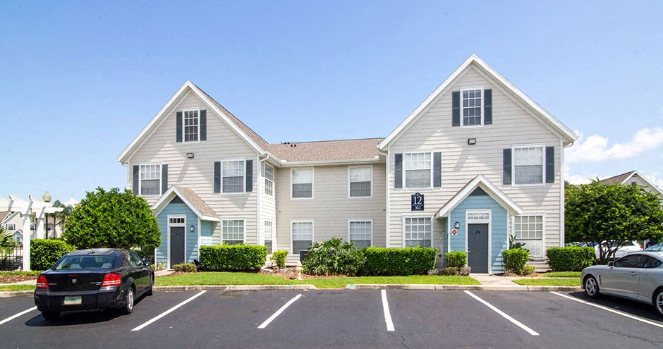 a large white house with cars parked in a parking lot