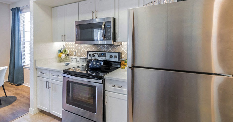 a kitchen with stainless steel appliances and a refrigerator