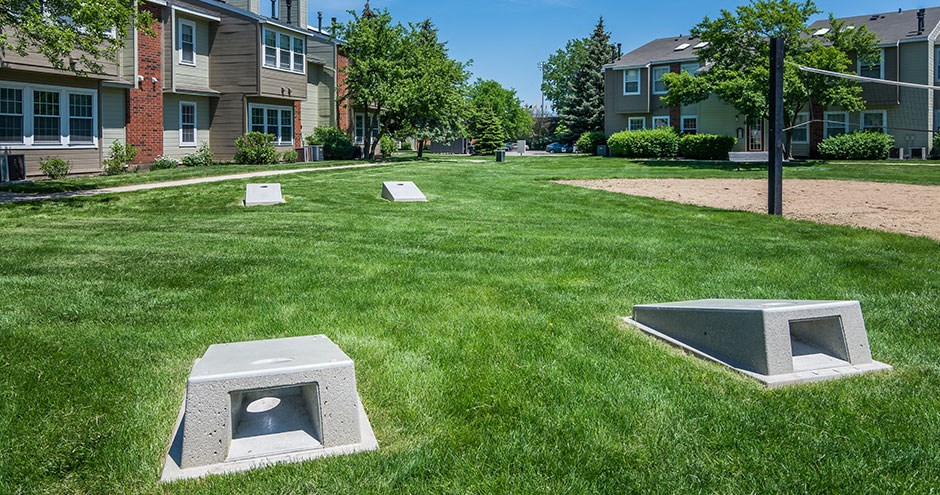 a grassy area with some concrete benches in the grass