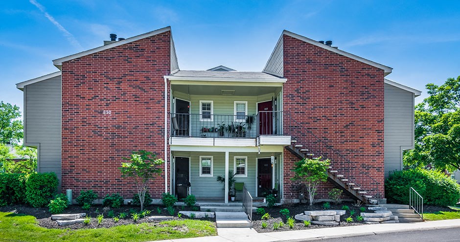 the front of a brick house with a balcony