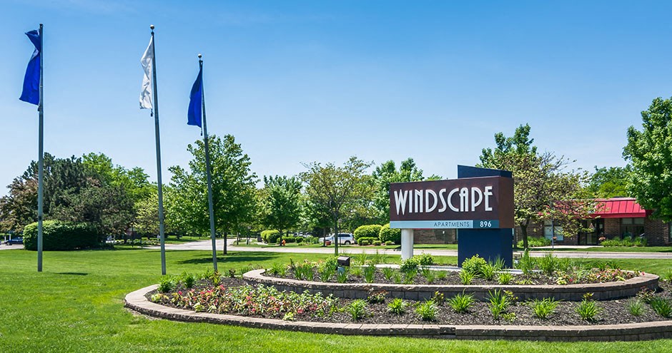 a park with a sign and flags