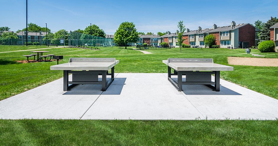 two ping pong tables on a patio in a park