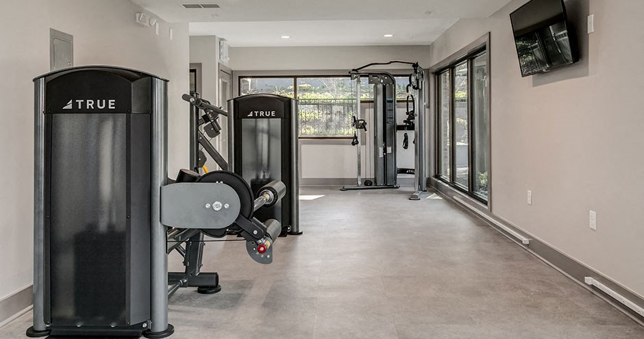 a home gym with exercise equipment and a large window