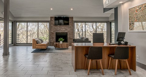 a living room with a fireplace and a desk with chairs