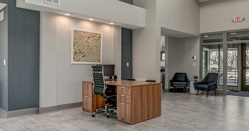 the lobby of a building with a desk and chairs
