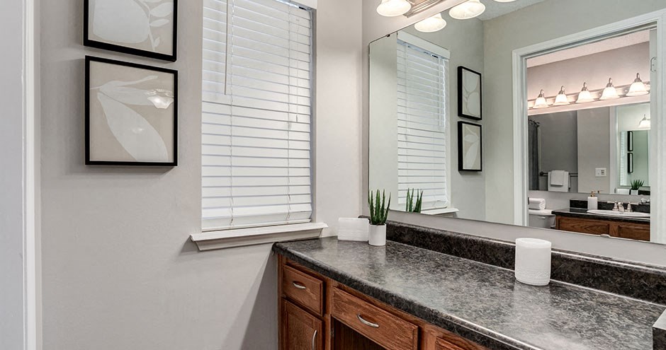 a bathroom with a granite counter top and a large mirror