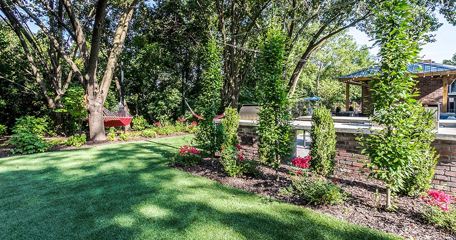 a backyard with a lawn and trees and a garden