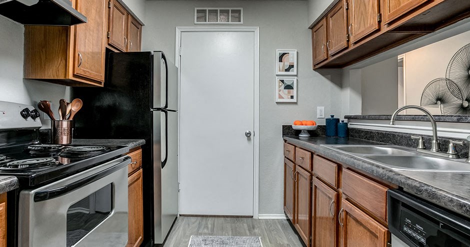 a kitchen with a stove refrigerator and sink