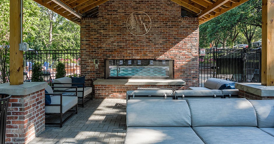 a patio with couches and a fire pit