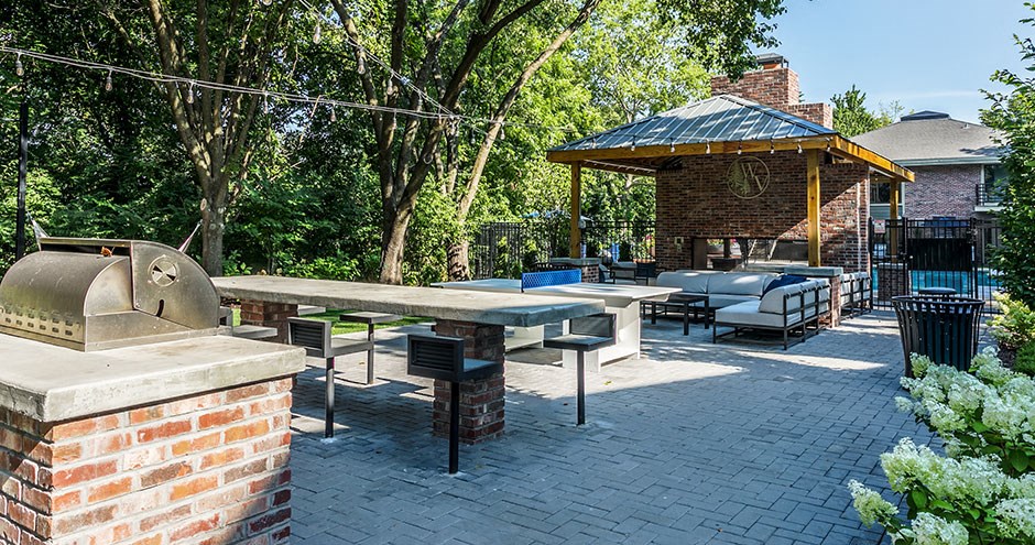 a brick outdoor patio with a pizza oven and tables