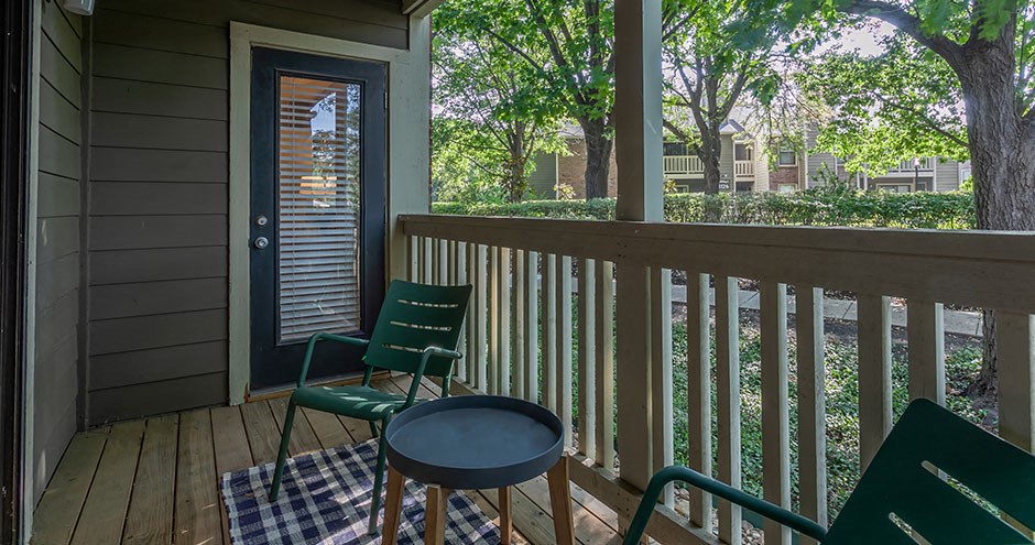 a patio with two chairs and a table on a porch