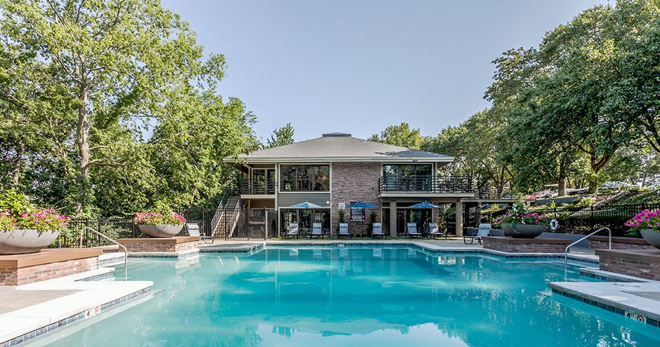 a swimming pool in front of a house with a pool
