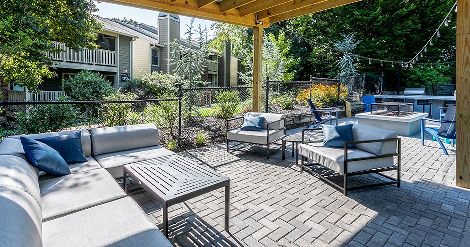 a patio with couches and chairs and a wooden structure