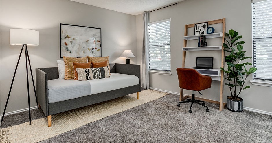 a bedroom with a bed and a desk with a chair